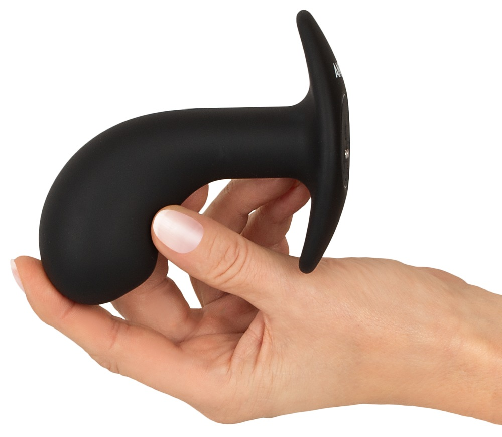 Eine Hand hält ein schwarzes, geschwungenes Sexspielzeug mit T-förmigem Griff auf weißem Hintergrund.