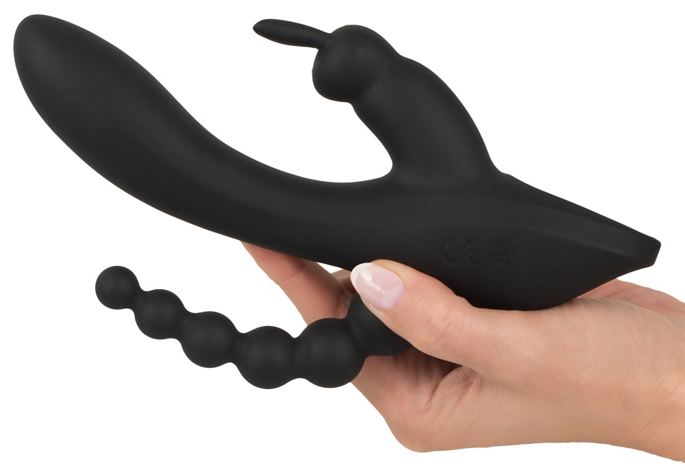 Eine Hand hält ein ergonomisch geformtes, schwarzes Wellness-Produkt gegen einen weißen Hintergrund.