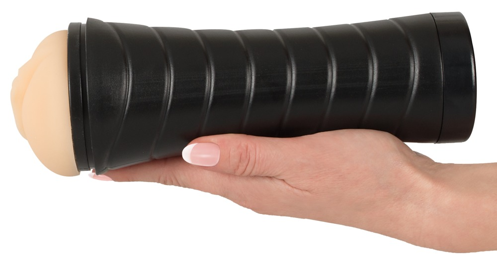 Eine Hand hält ein schwarzes, geripptes zylindrisches Objekt mit beiger Spitze vor weißem Hintergrund.