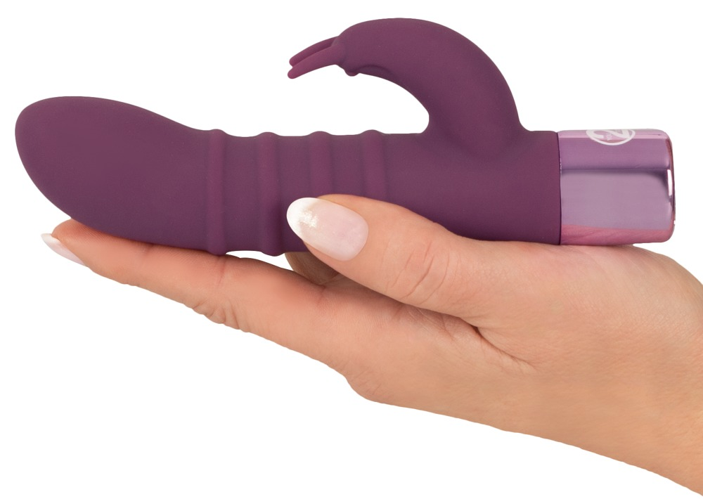 Eine Hand hält einen lila gerippten Vibrator mit Metallbasis und geschwungenem Klitorisstimulator vor weißem Hintergrund.
