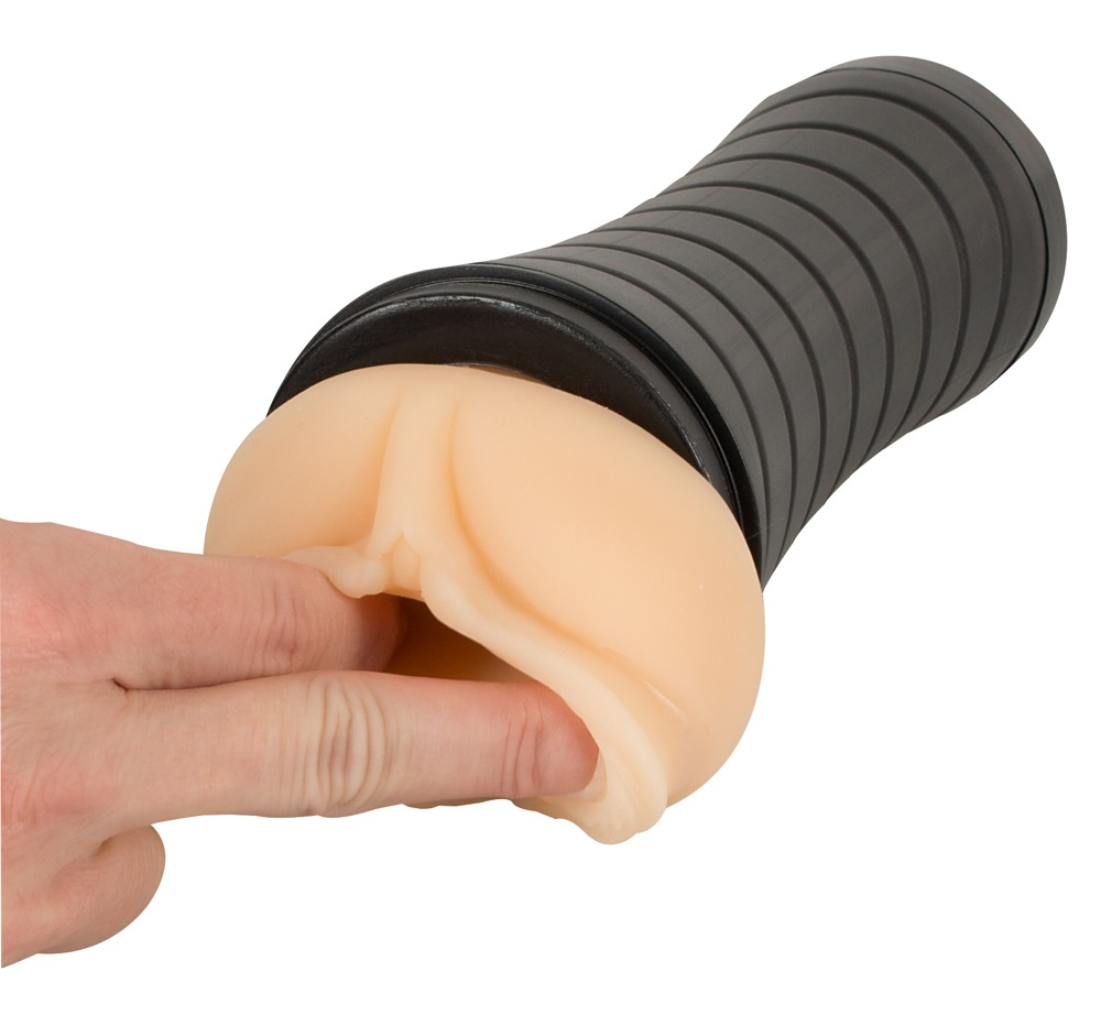 Finger berühren das weiche, hautfarbene Material eines Masturbators mit schwarzem Gehäuse.