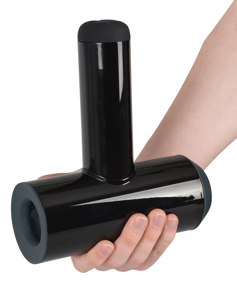 Eine Hand hält ein schwarzes, T-förmiges Massagegerät mit glänzender Oberfläche vor einem weißen Hintergrund.