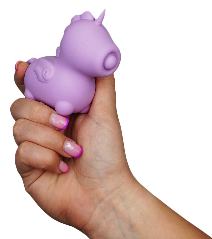 Eine Hand hält ein violettes Einhorn-Quetschspielzeug vor weißem Hintergrund.