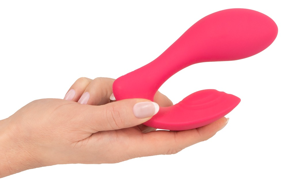 Eine Hand hält einen rosa, ergonomischen Vibrator vor weißem Hintergrund.