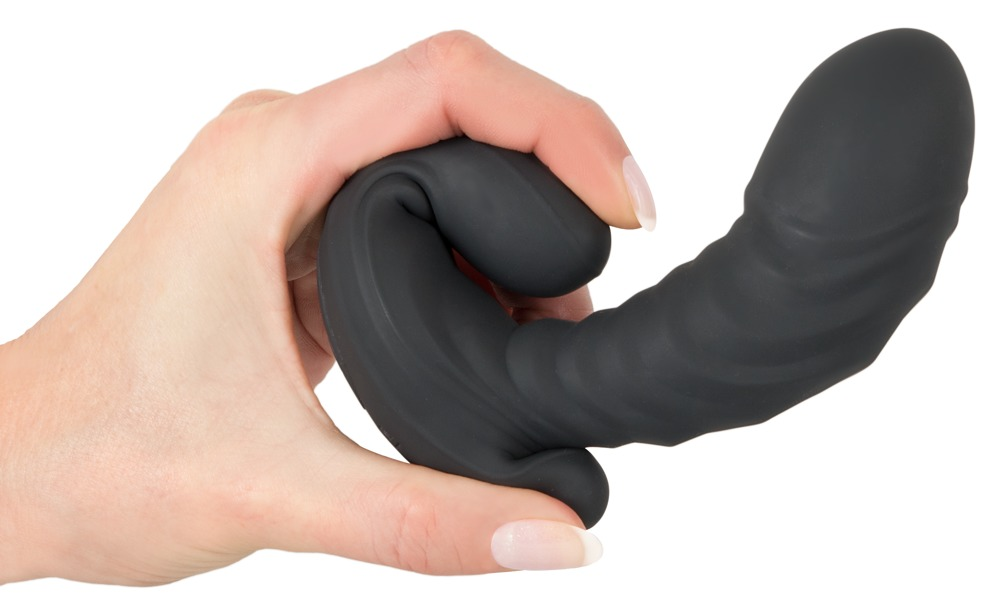 Eine Hand hält ein schwarzes, geschwungenes Silikon-Sexspielzeug vor weißem Hintergrund.