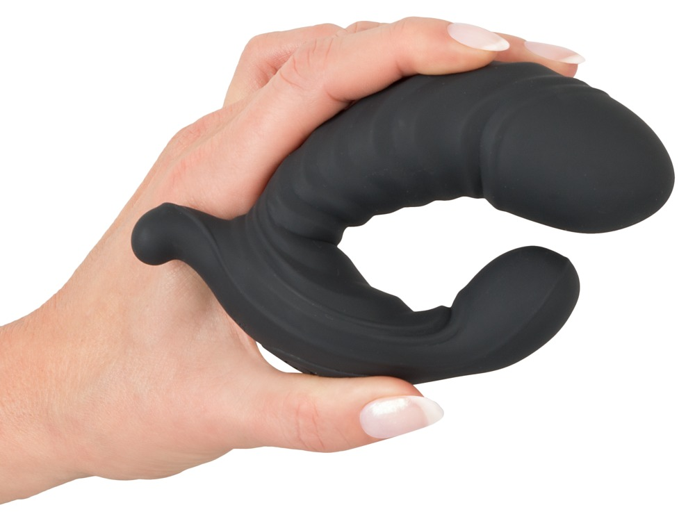 Eine Hand hält ein geschwungenes, schwarzes Sexspielzeug aus Silikon vor weißem Hintergrund.