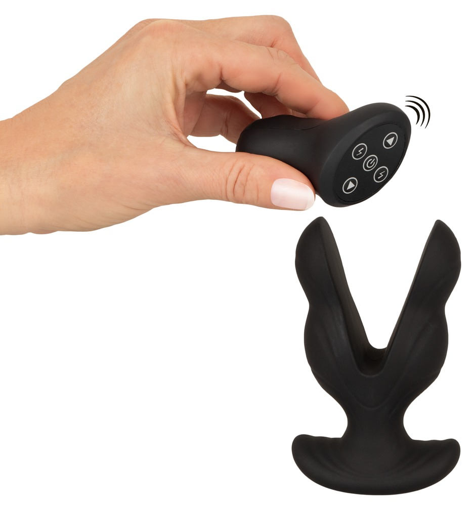 Eine Hand hält eine schwarze Fernbedienung neben einem schwarzen V-förmigen Wellness-Spielzeug.