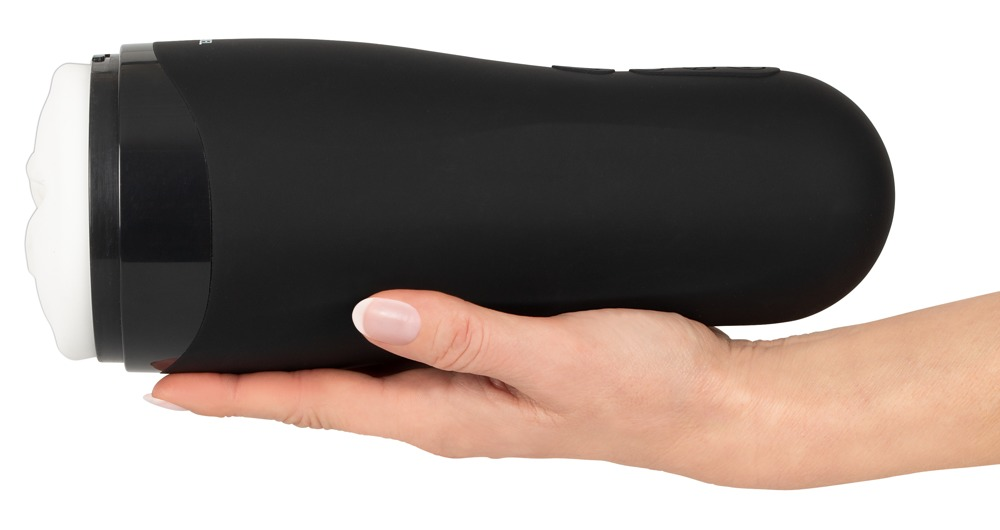 Eine Hand hält ein schwarzes, zylindrisches Lifestyle-Produkt mit weißem Einsatz auf weißem Hintergrund.