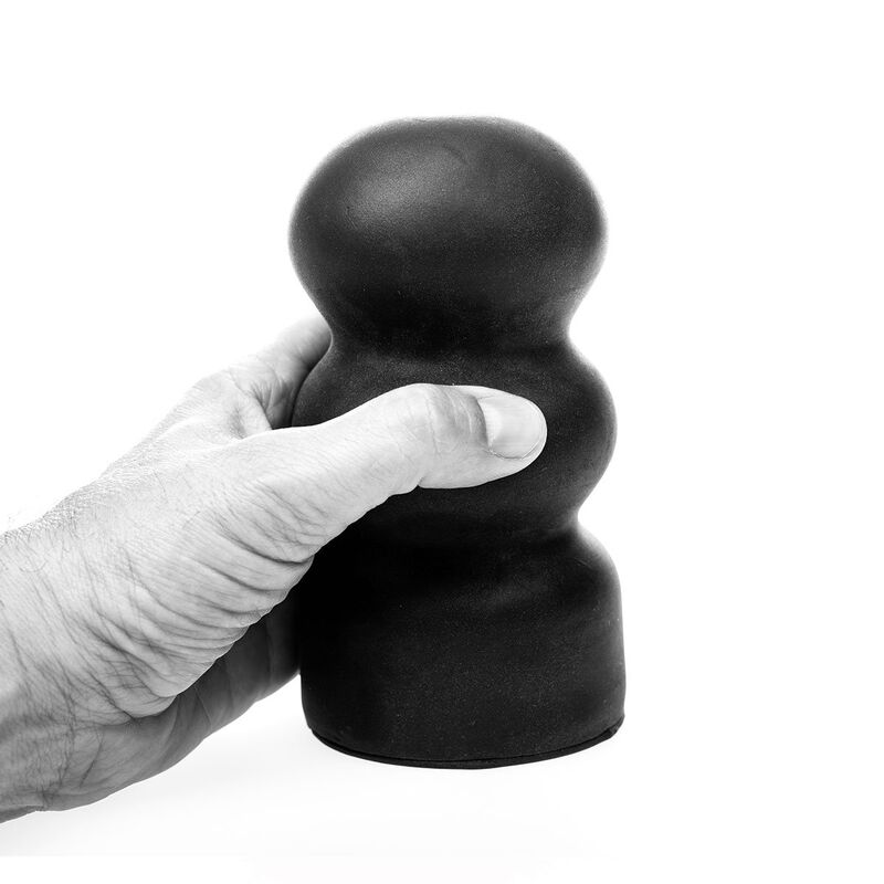 Eine Hand hält ein schwarzes, rundes Objekt mit drei knolligen Abschnitten vor weißem Hintergrund.