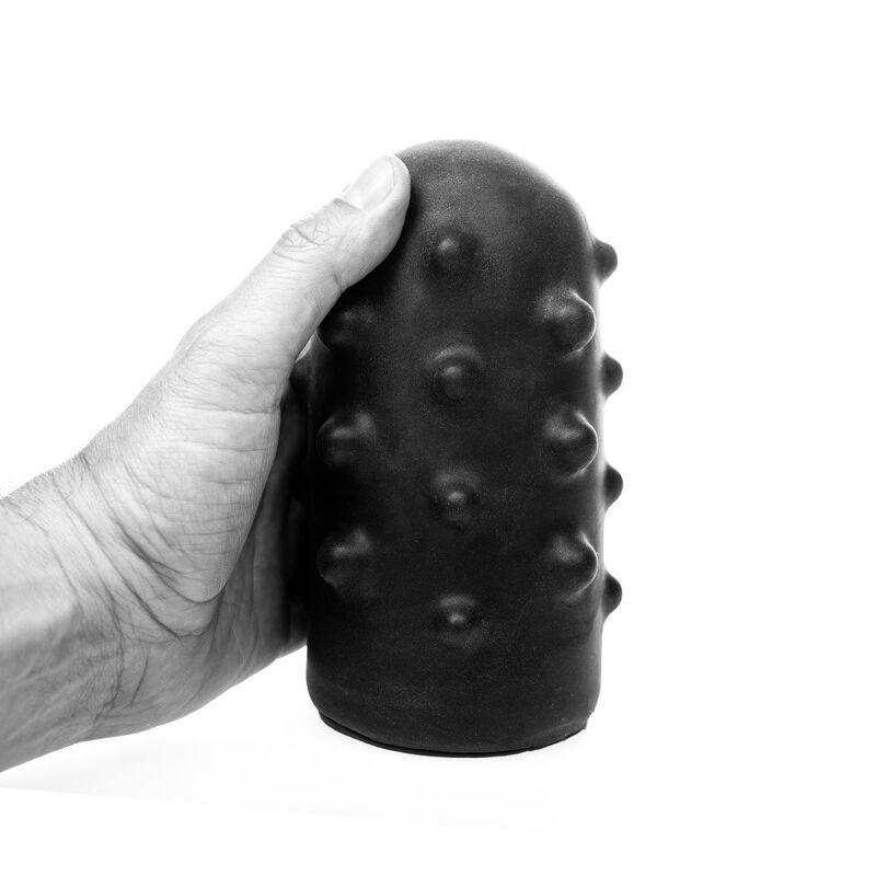 Eine Hand hält einen schwarzen, genoppten zylindrischen Gegenstand auf weißem Hintergrund.