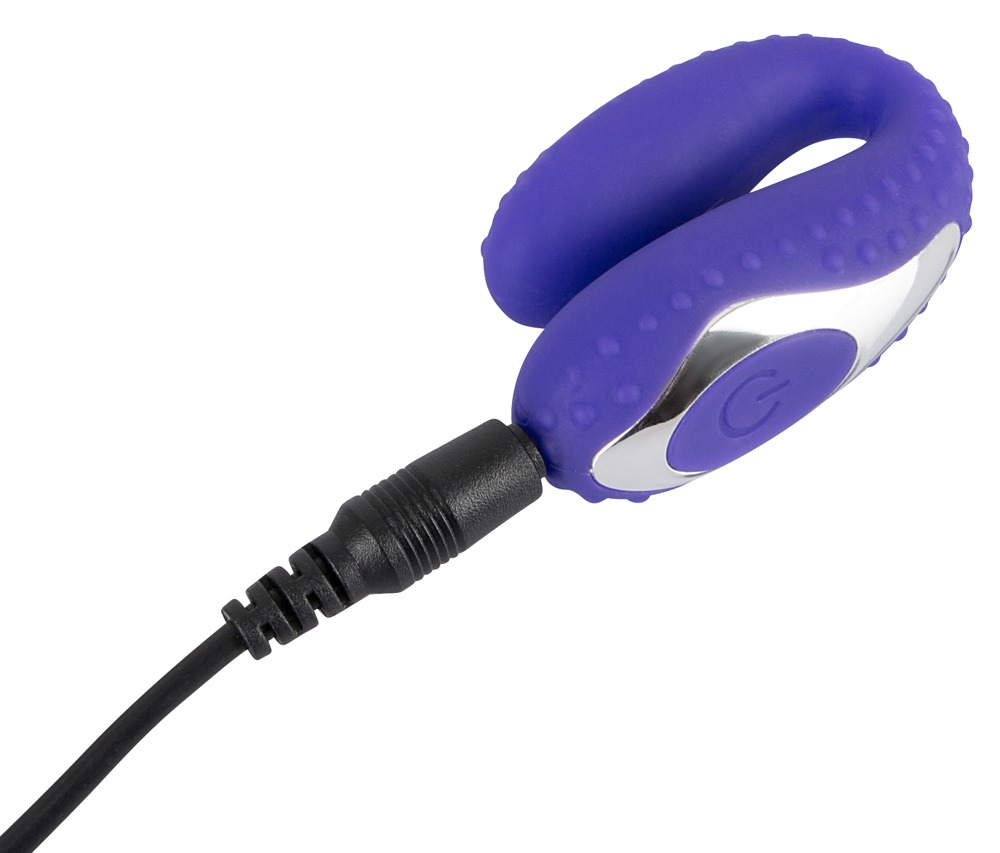 Ein lila U-förmiges Gerät mit Silikon und silbernem Einschaltknopf ist an ein schwarzes Ladekabel angeschlossen.