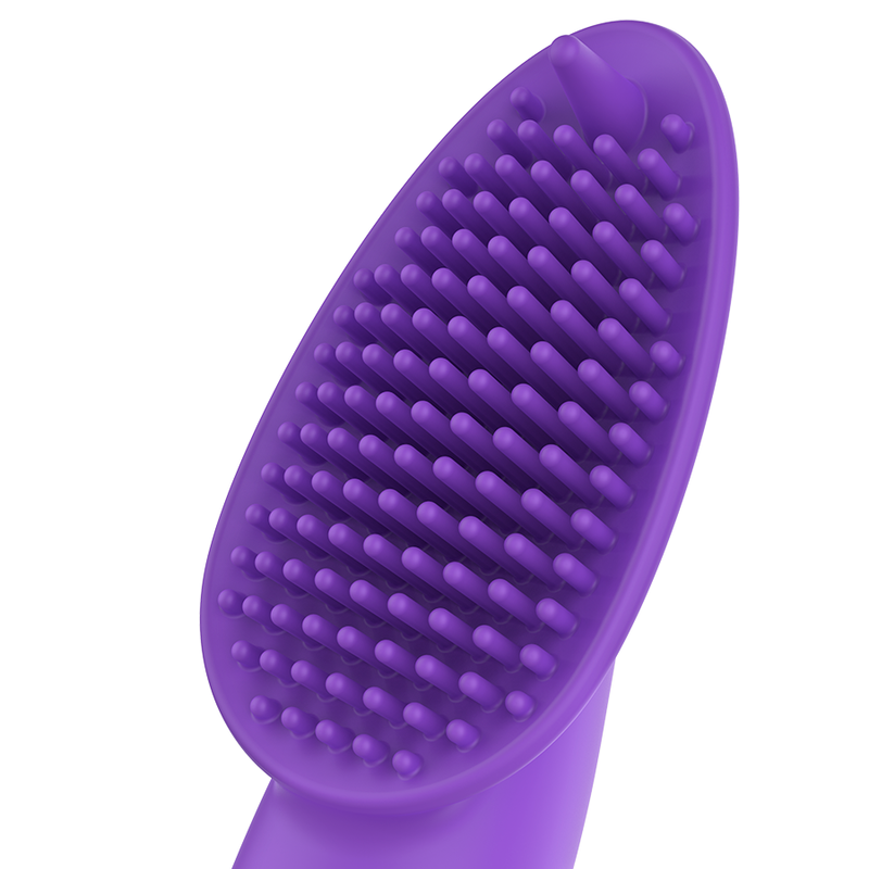 Eine violette Silikonbürste mit vielen feinen Noppen für die sanfte Pflege gegen einen weißen Hintergrund.