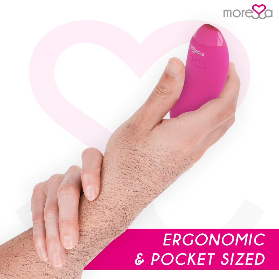 Una mano sostiene un pequeño dispositivo de bienestar ergonómico rosa sobre fondo blanco con un corazón rosa.