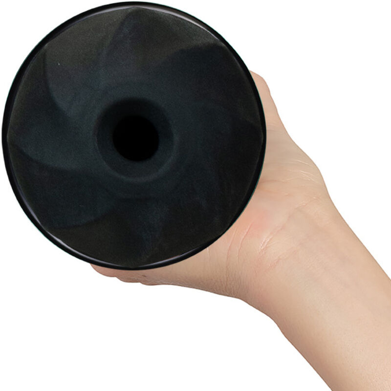 Eine Hand hält einen schwarzen, runden Gegenstand mit einer Öffnung in der Mitte und spiralförmigem Muster.