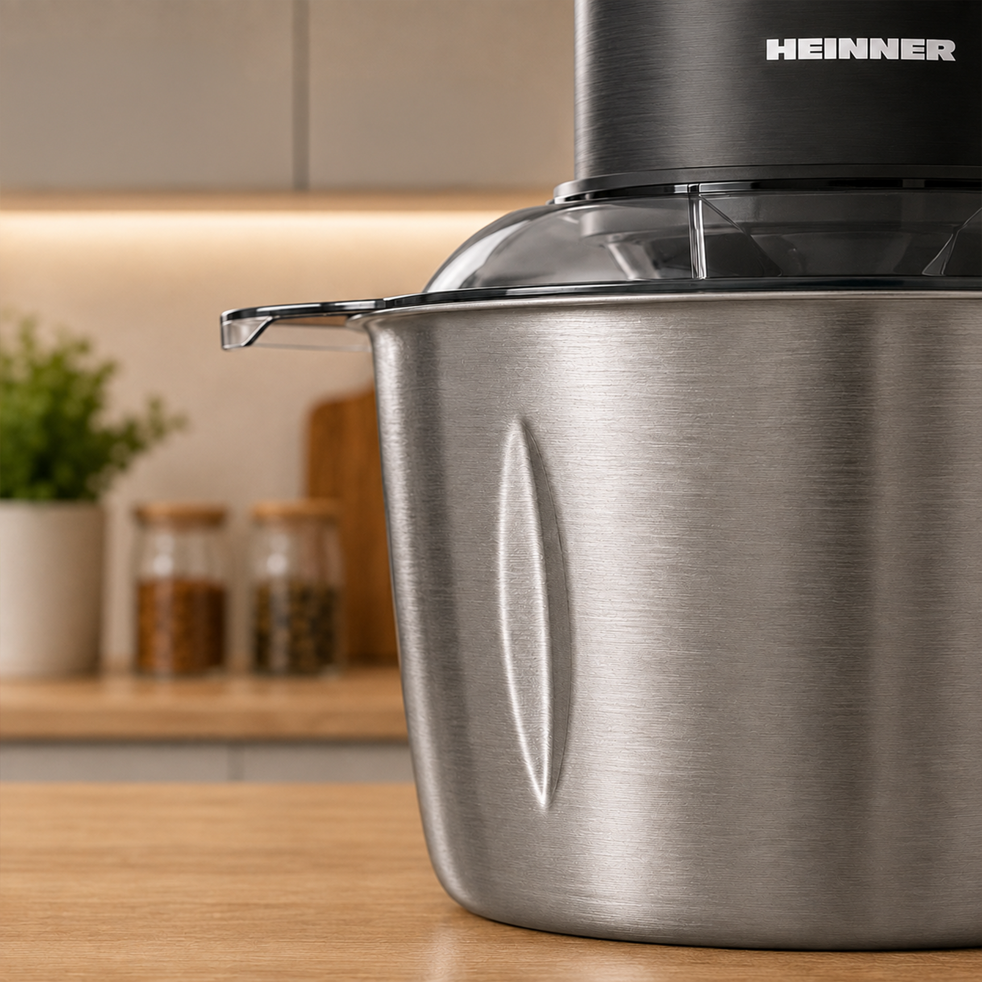 Een zilveren Heinner keukenmixer staat op een houten aanrecht in een moderne keuken.