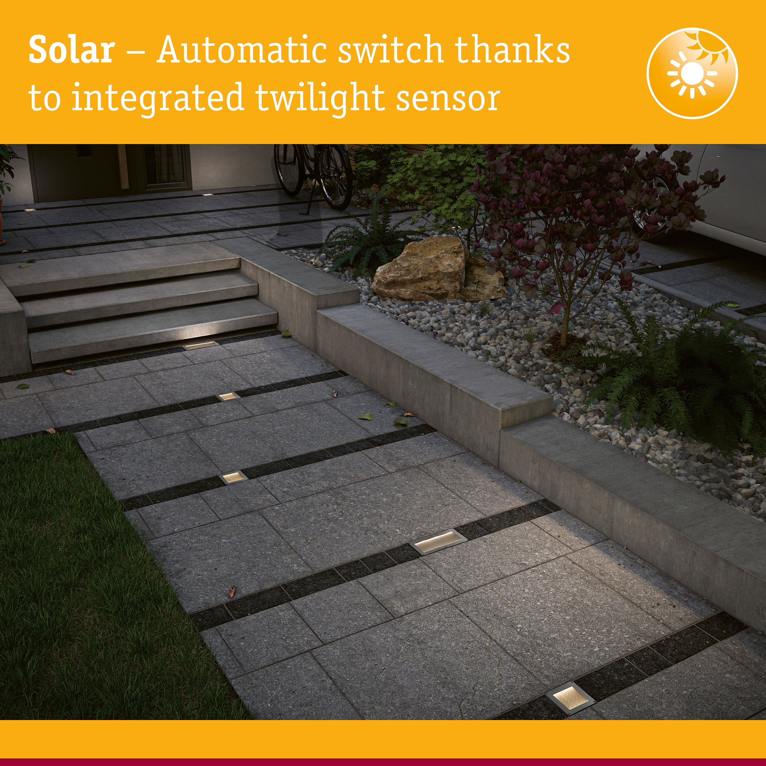 Beleuchteter Gehweg aus Pflastersteinen mit integrierten Solarleuchten, angrenzend an eine Treppe und Gartenbeete.