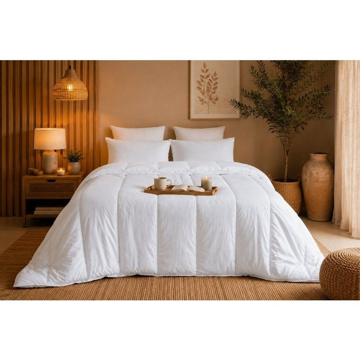 Gemütliches Schlafzimmer mit weißem Daunenbett, Nachttisch, Pflanze und warmer Beleuchtung vor Beigewand.