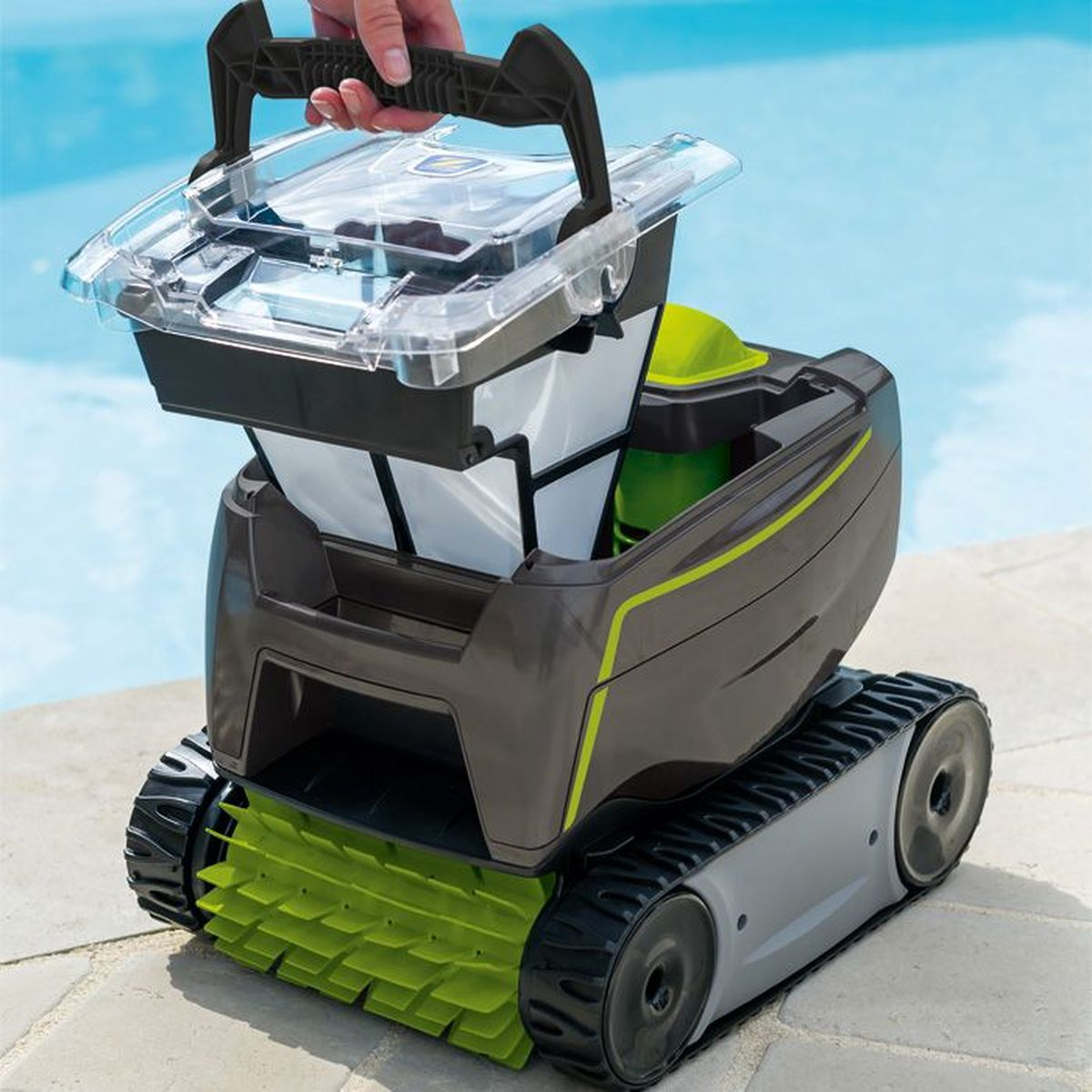 Eine Hand hebt den transparenten Filterbehälter aus einem graugrünen Roboter-Poolreiniger.