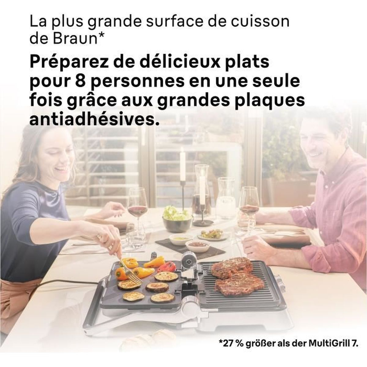 Una coppia è seduta a una tavola apparecchiata con una griglia elettrica da tavolo per carne e verdure.