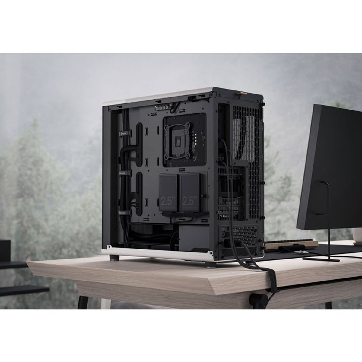 PC case showing organized cable management on a wooden desk against a blurred background.