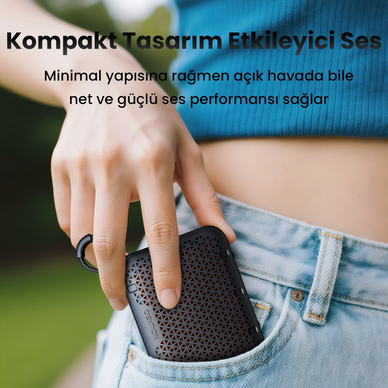 Osoba chowa mały czarny głośnik Bluetooth do kieszeni niebieskich dżinsów.