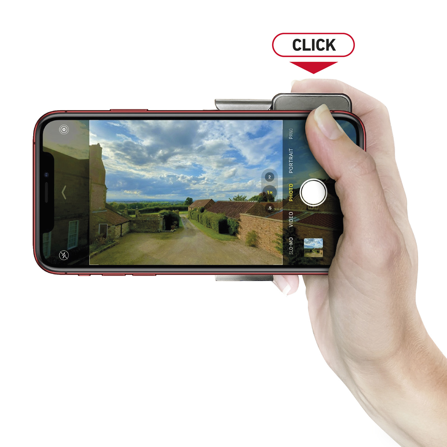 Mano sostiene un smartphone rojo con accesorio de cámara, mostrando foto de paisaje y botón superior.