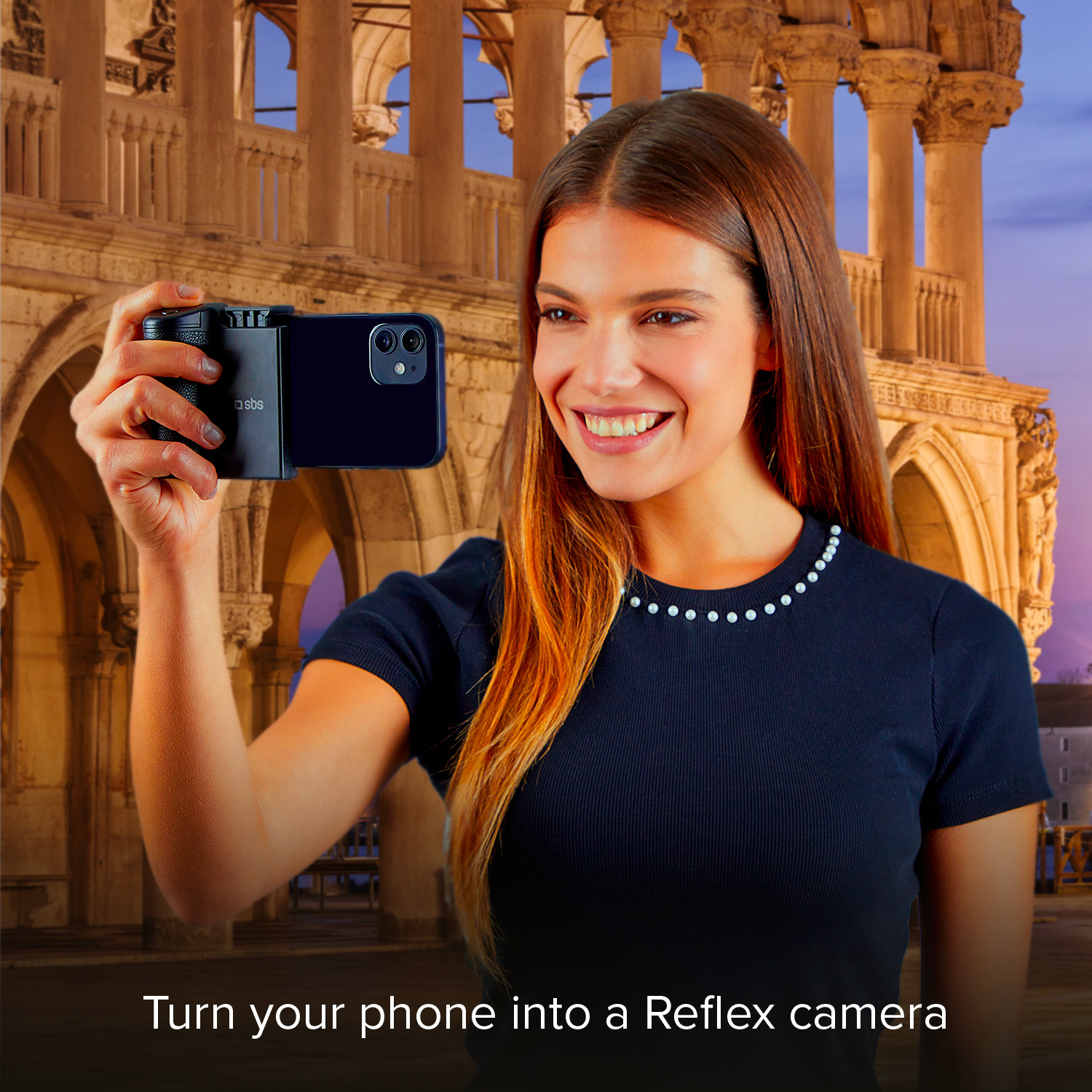 Una mujer sonriente toma una foto con un teléfono en un soporte de cámara ante un fondo histórico.