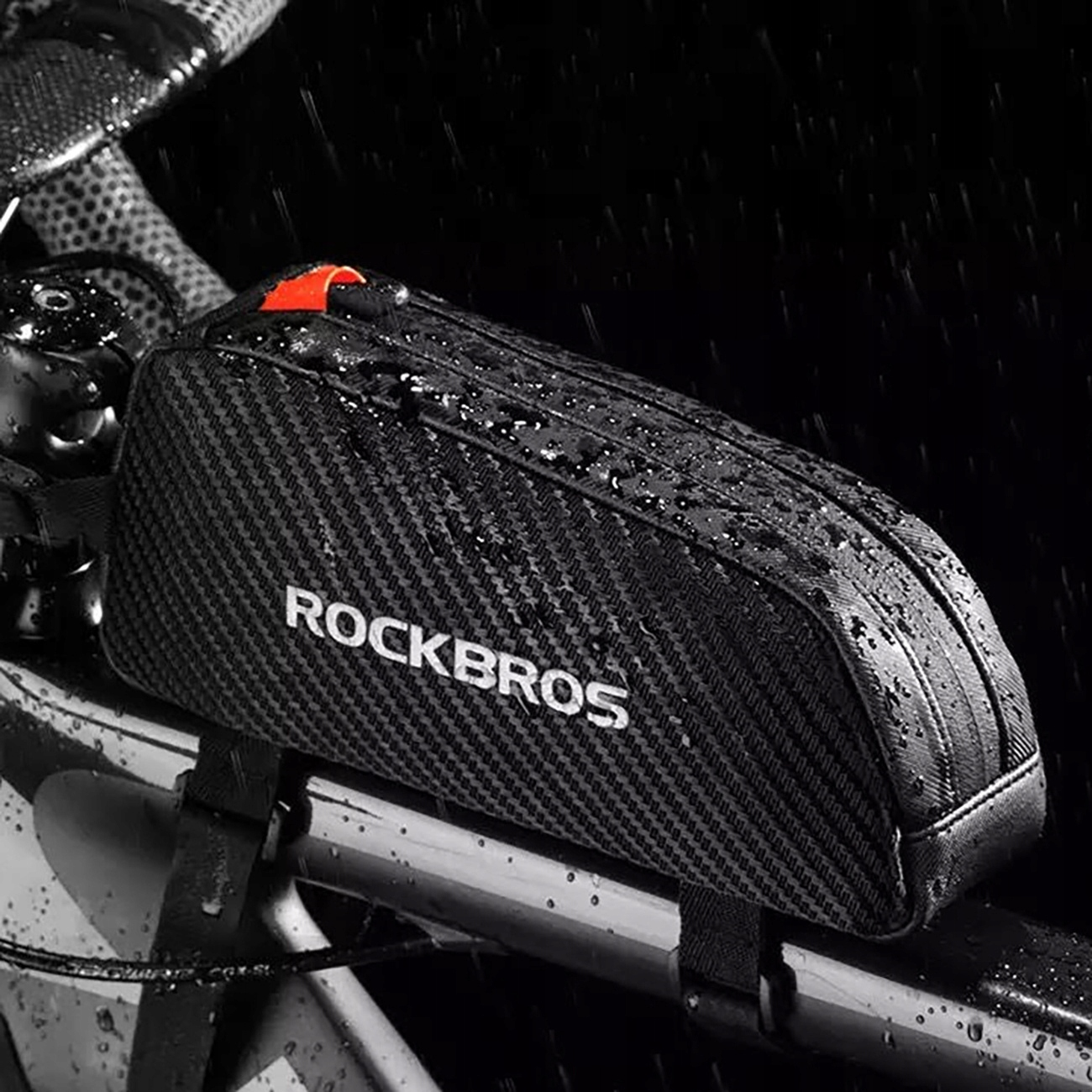 Una borsa da telaio nera RockBros montata su una bicicletta sotto la pioggia, coperta di gocce d'acqua.