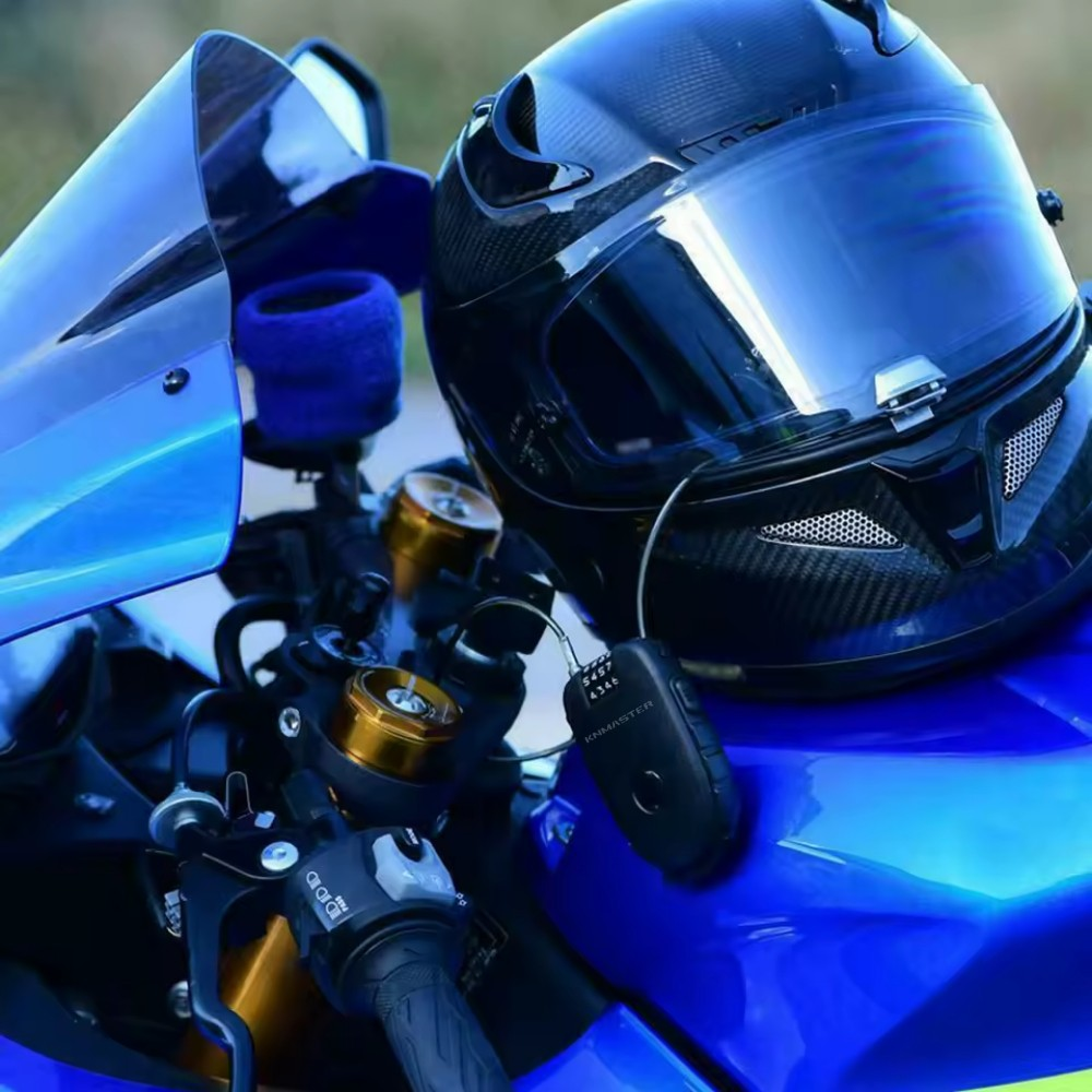 Siyah bir kask, motosikletin mavi yakıt deposu üzerinde gidona yakın duruyor.