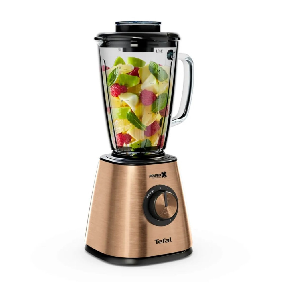 Różowozłoty blender Tefal ze szklanym dzbankiem wypełnionym świeżymi owocami i liśćmi mięty na białym tle.