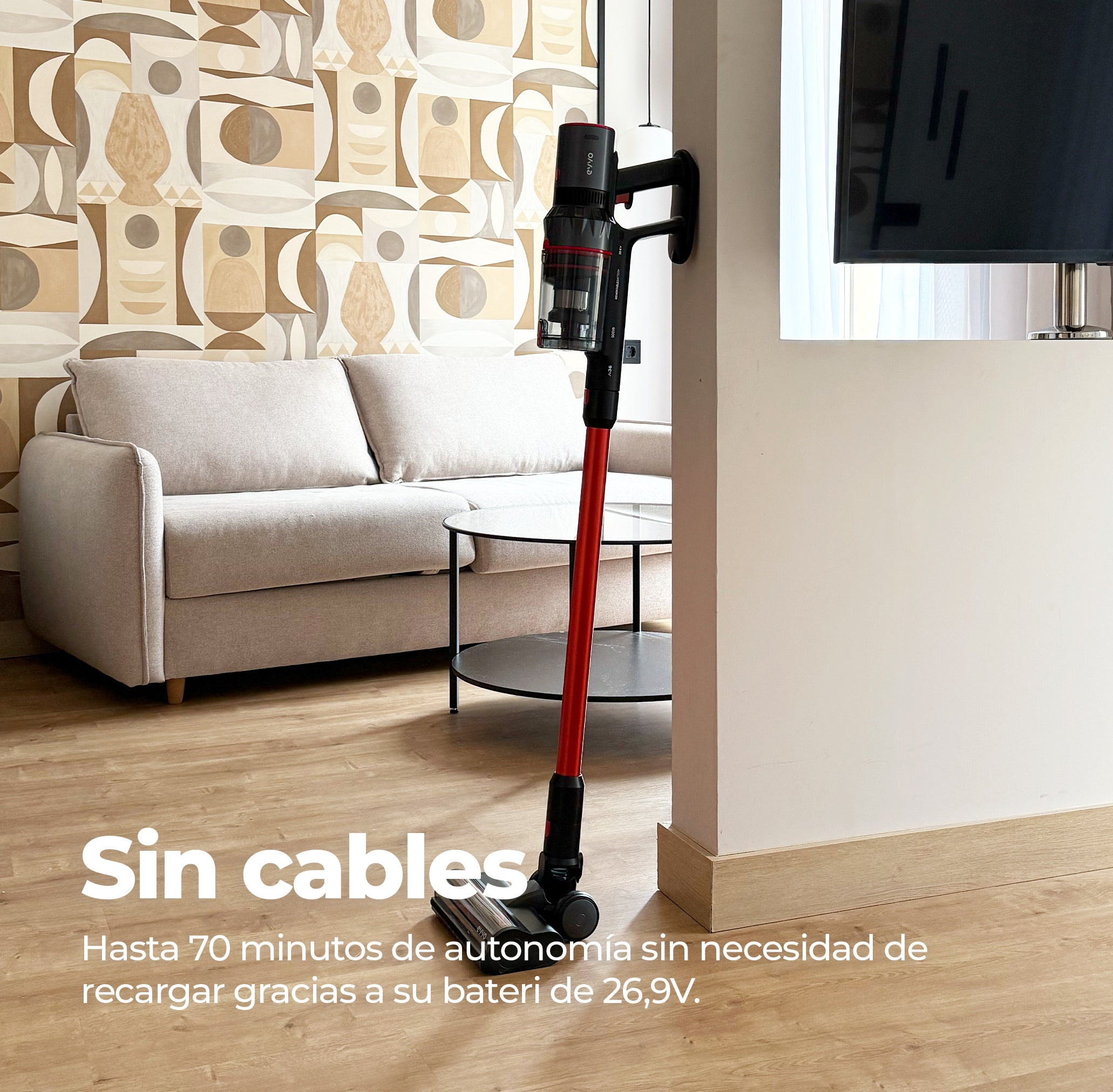 Una aspiradora sin cable roja y negra en una sala de estar moderna.