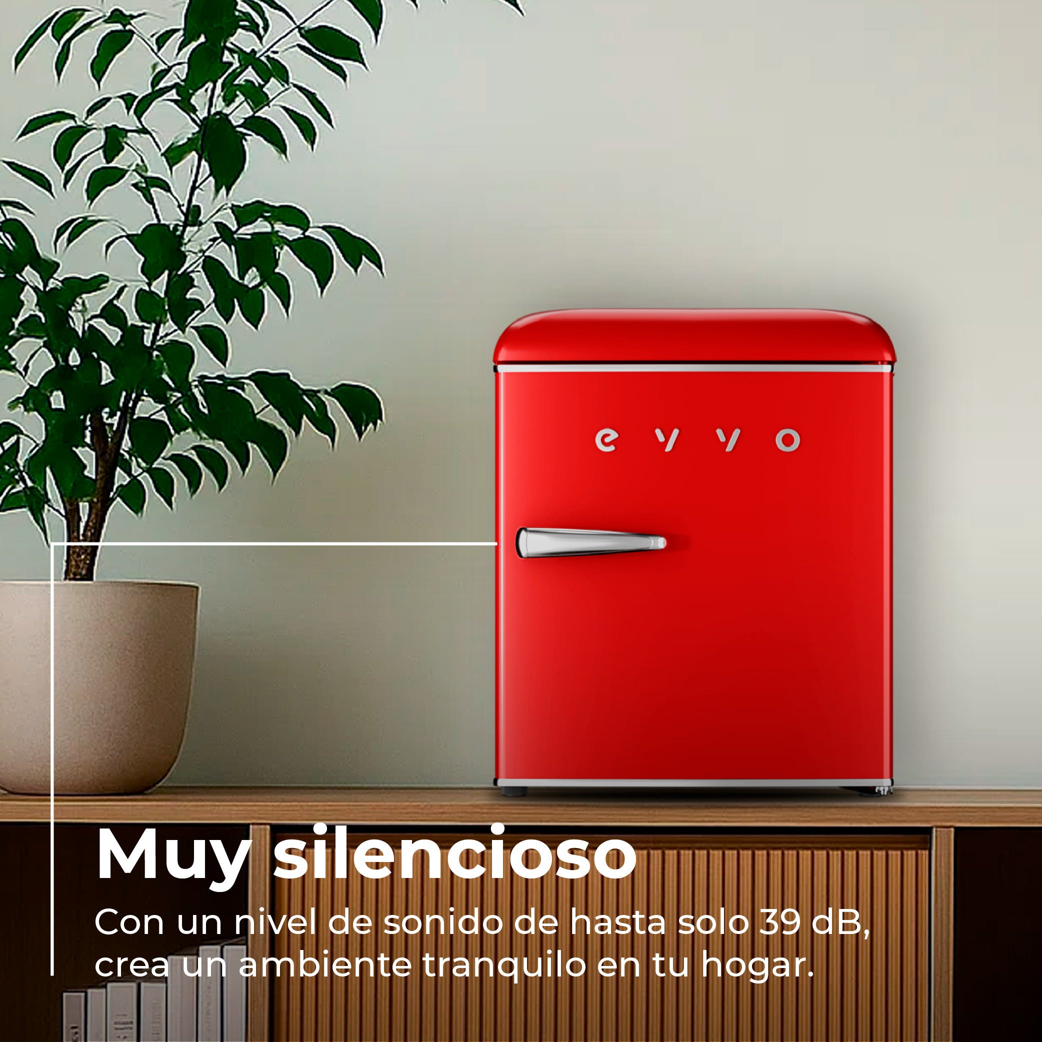 Mini nevera roja retro sobre un mueble de madera junto a una planta.
