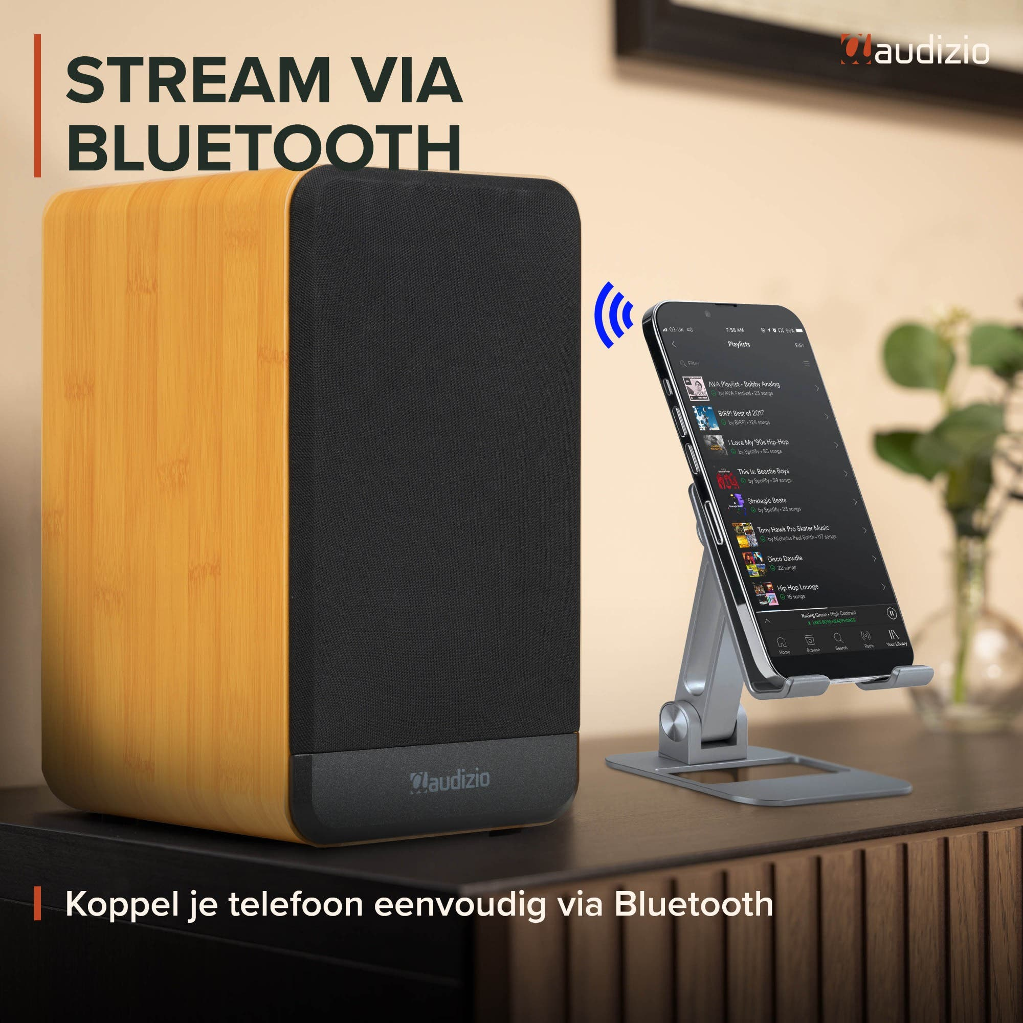 Un altavoz Audizio con acabado de madera transmite música de forma inalámbrica desde un teléfono en un soporte.