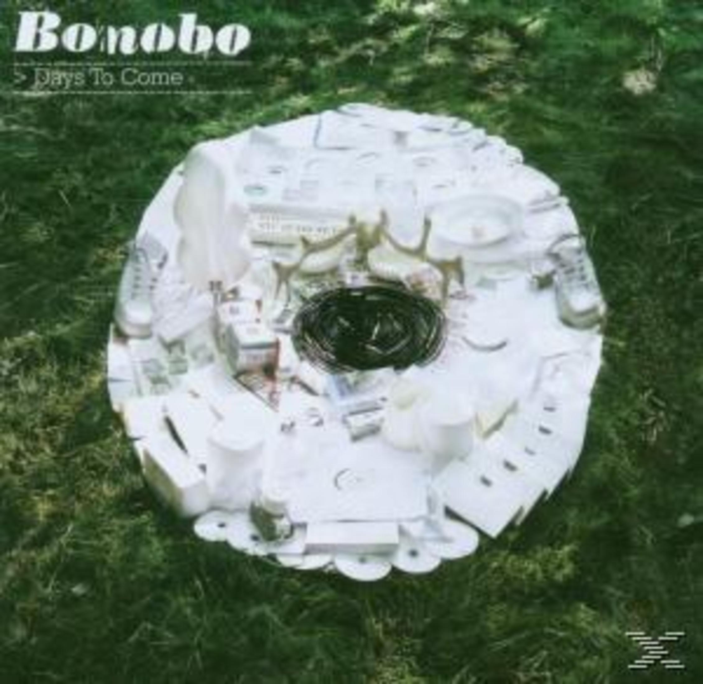Eine ovale Sammlung weißer Gegenstände auf Gras mit dem Text Bonobo Days To Come oben links.