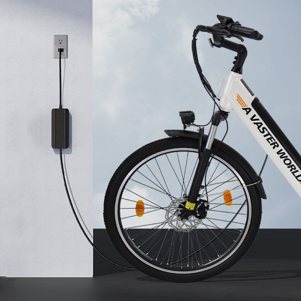 Una bicicleta eléctrica blanca está enchufada a un tomacorriente de pared y se carga.