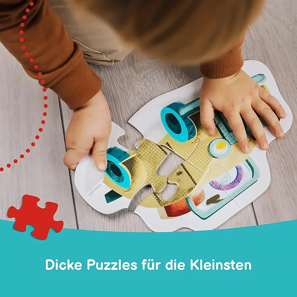 Kleinkind setzt ein großes Puzzle auf dem Holzfußboden zusammen.