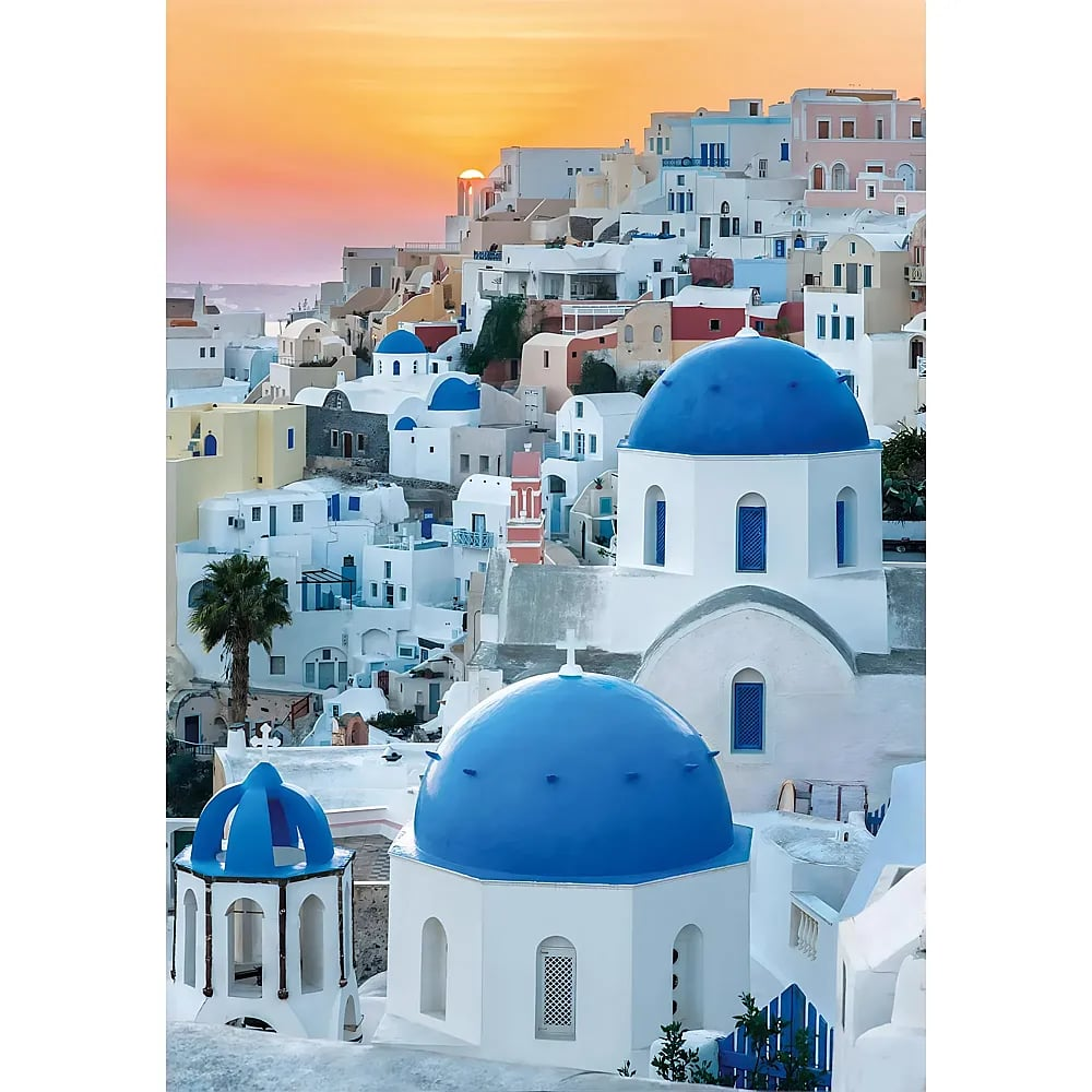 Edifici bianchi con cupole blu a Oia, Santorini, durante un suggestivo tramonto.