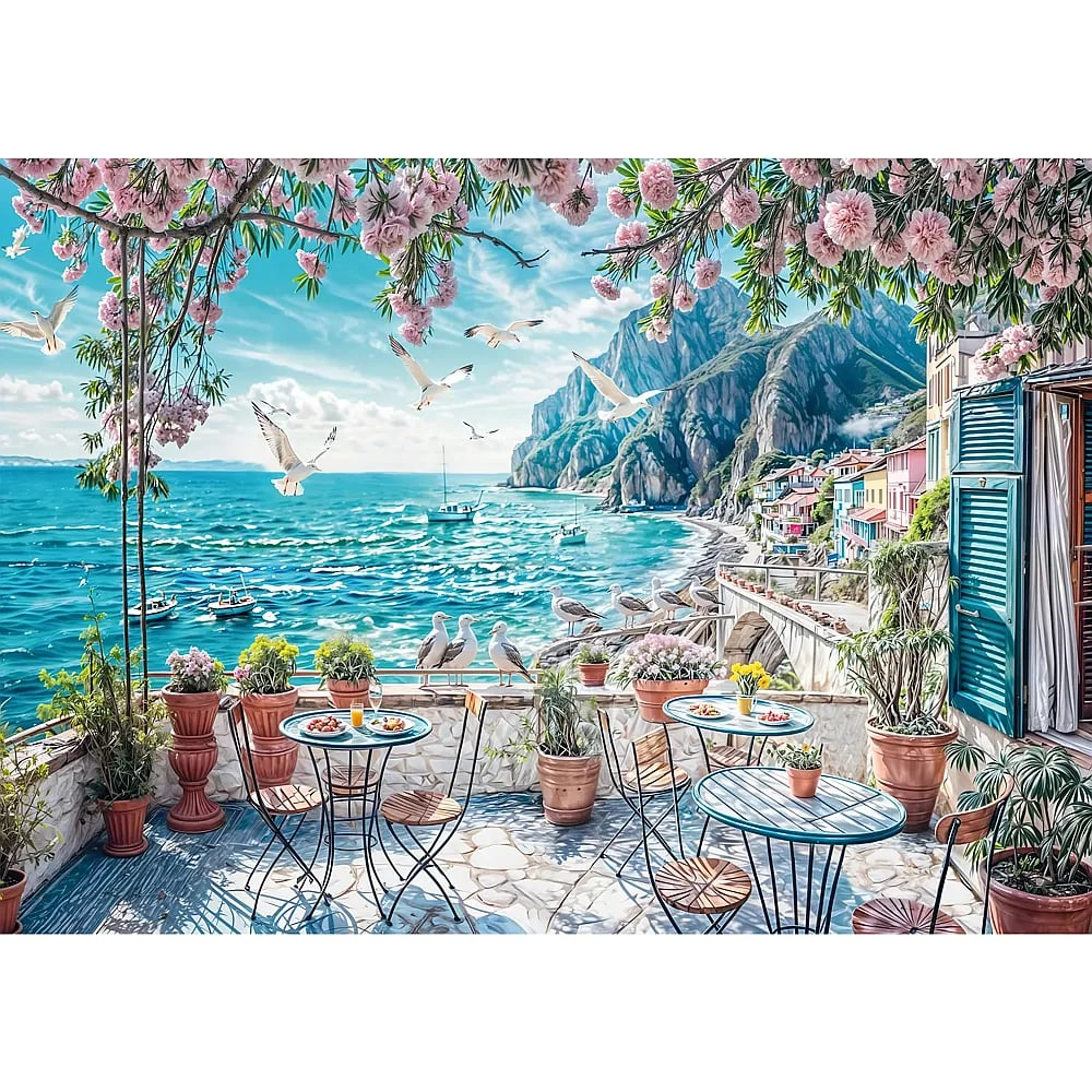 Ein malerischer Balkon mit Tischen mit Blick auf das Meer, umrahmt von rosa Blumen, mit Bergen und Möwen im Hintergrund.