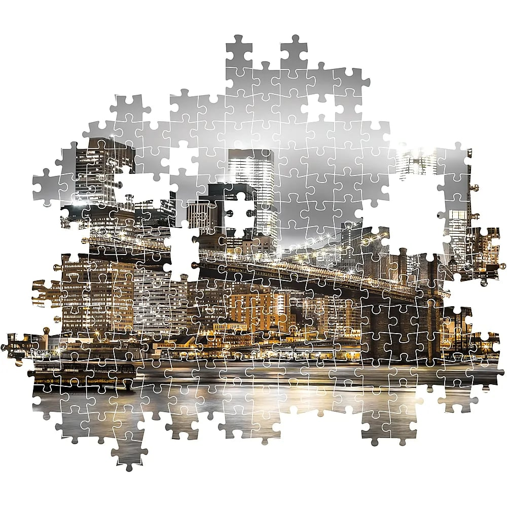 An incomplete jigsaw puzzle shows the night skyline of New York City with the Brooklyn Bridge.