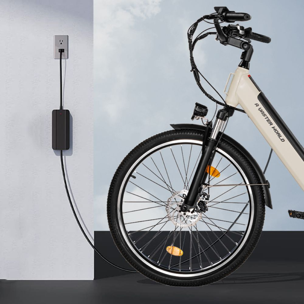 Una bicicleta eléctrica blanca cargándose en un enchufe de pared con un cable negro.
