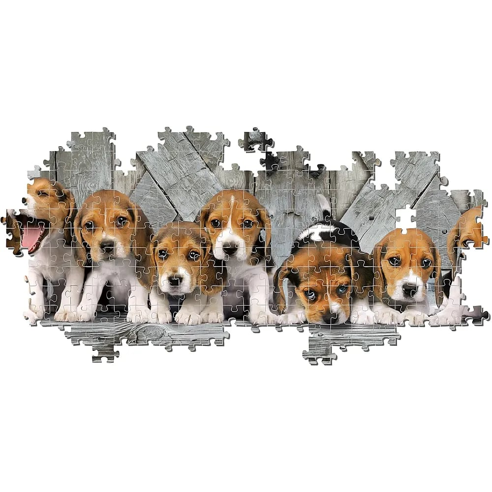 Un puzzle incompleto mostra diversi cuccioli di beagle davanti a una parete di legno.