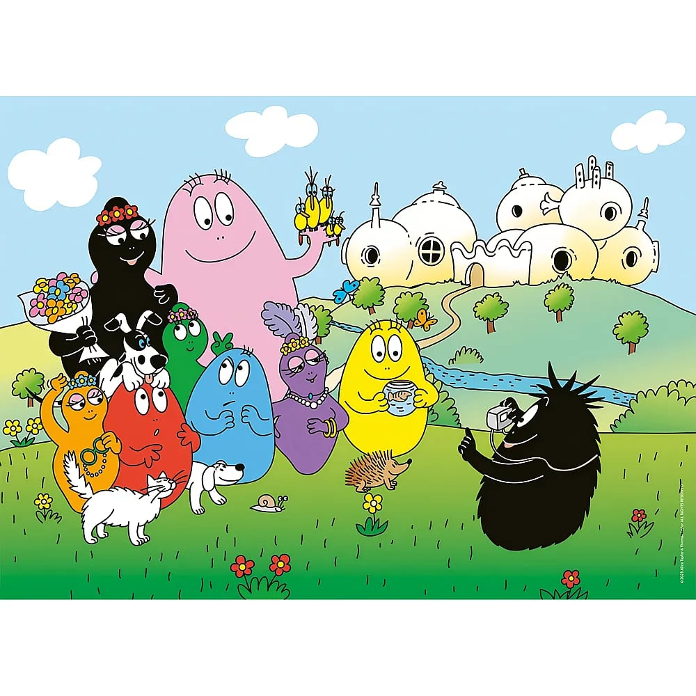 Bunte Barbapapa-Familie posiert im Gras vor ihren kuppelförmigen Häusern für ein Foto.