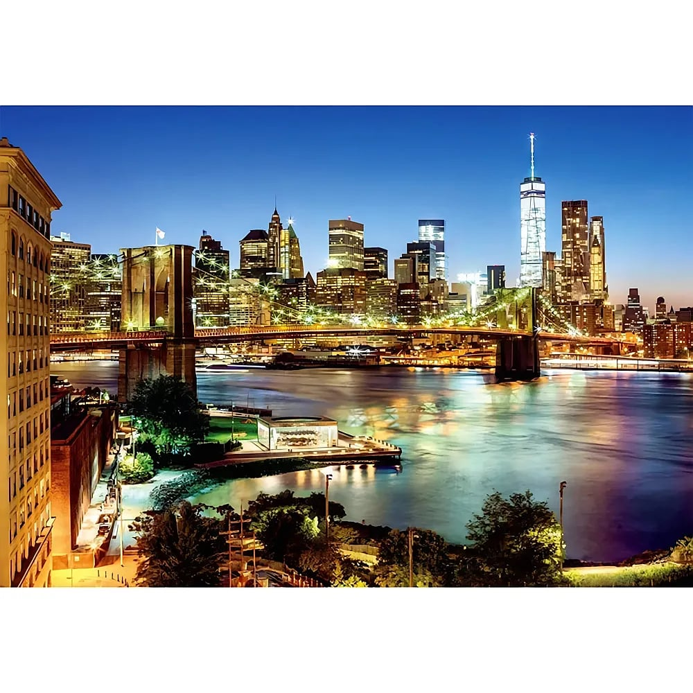 Nächtlicher Blick auf die Skyline von New York und die Brooklyn Bridge über den Fluss.