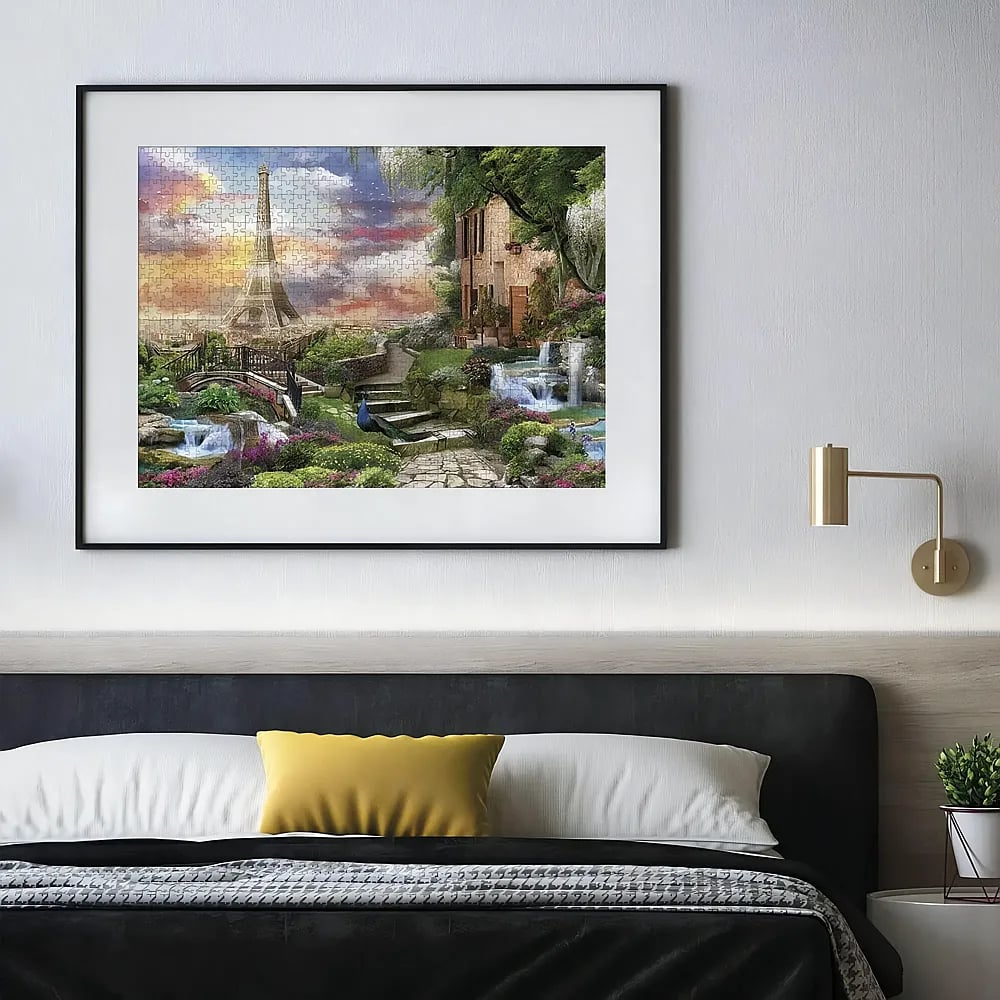 Eingerahmtes Puzzle über dem Bett zeigt den Eiffelturm, einen Garten und kleine Wasserfälle.