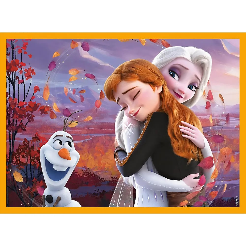 Elsa e Anna si abbracciano calorosamente mentre Olaf sorride nel bosco autunnale.
