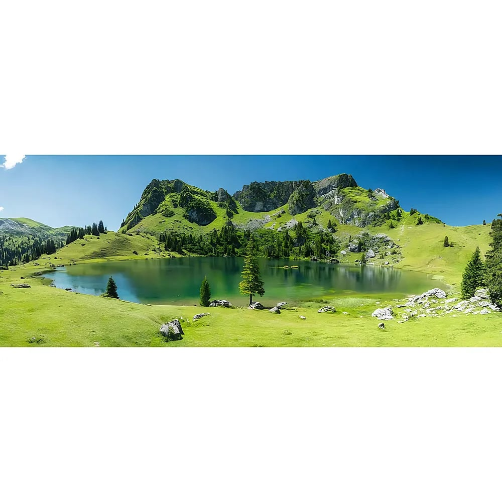 Un lac alpin reflète des montagnes vertes et un ciel bleu, entouré de prairies et d'arbres.