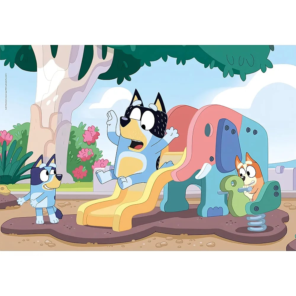 Perros azules juegan en un colorido parque infantil de elefantes en un parque con césped verde y árboles.
