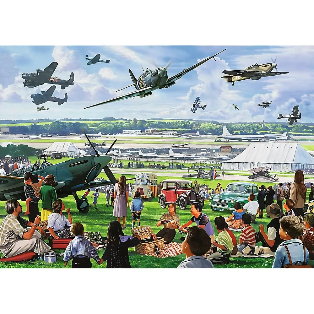 Menschen machen Picknick auf einem Flugfeld, während historische Jagdflugzeuge und Autos zu sehen sind.