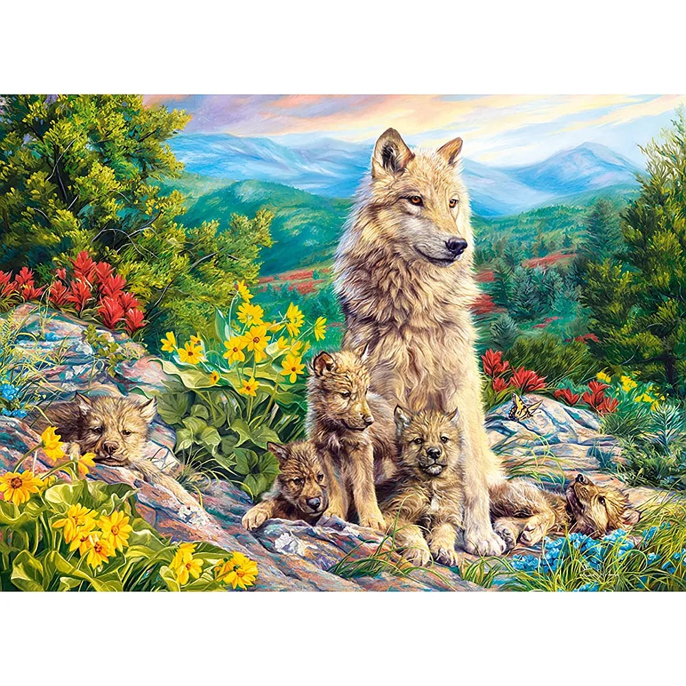Ein Wolf sitzt stolz mit seinen Welpen auf einem felsigen Hügel mit gelben und roten Blumen und Bergen im Hintergrund.