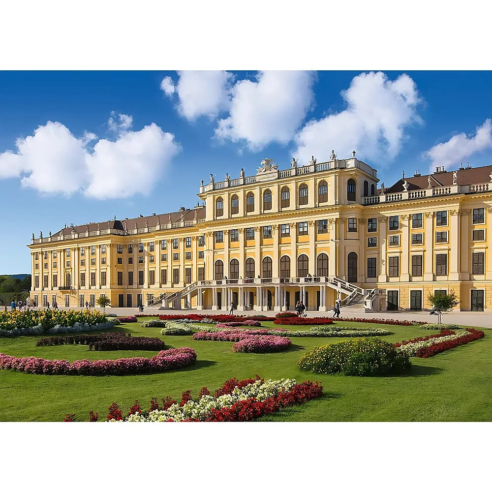Das gelbe Schloss Schönbrunn unter blauem Himmel mit Gärten im Vordergrund.